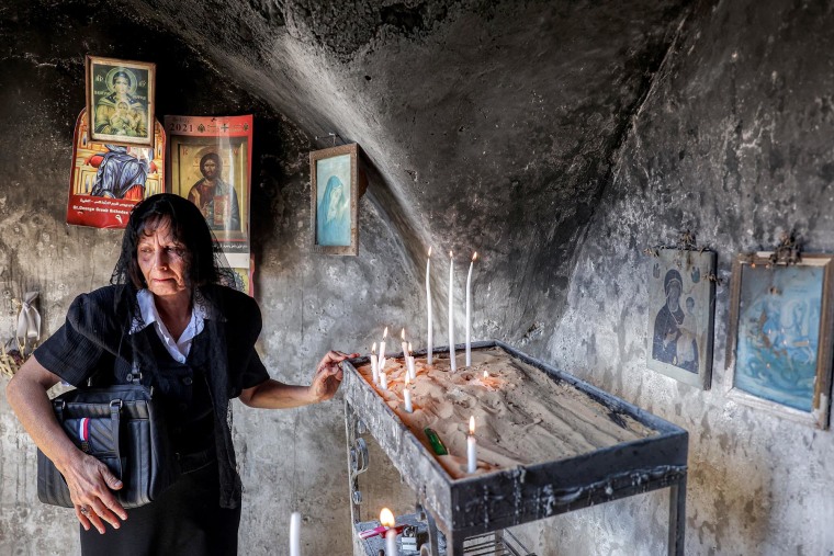 A Christian resident lights a candle at the fifth-century Church of St. George in the Palestinian Christian village of Taybeh, northeast of Ramallah in the occupied West Bank on July 14, 2025.