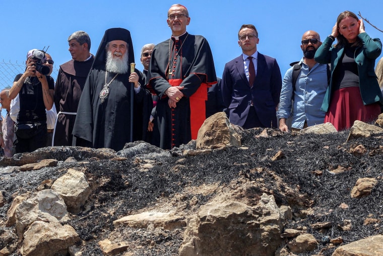 Latin Patriarch of Jerusalem Pierbattista Pizzaballa and Greek Orthodox Patriarch of Jerusalem Theophilos III stand together during a visit by the head clergymen of several Christian denominations to the Church of St. George in Taybeh in the West Bank on July 14, 2025, days after an arson incident on the site reportedly by Israeli settlers.