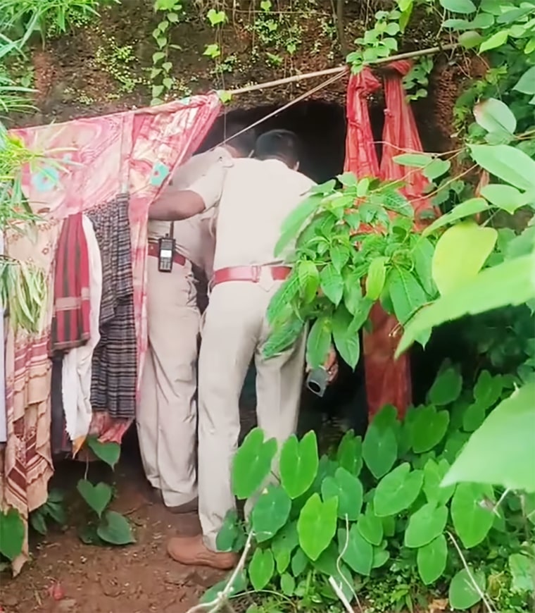 Police officers search the cave after discovering a Russian woman and her two children were living there.