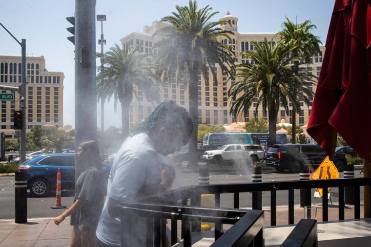 A person cools off by misters along the Las Vegas Strip as temperatures approach 110 degrees on July 14, 2025.