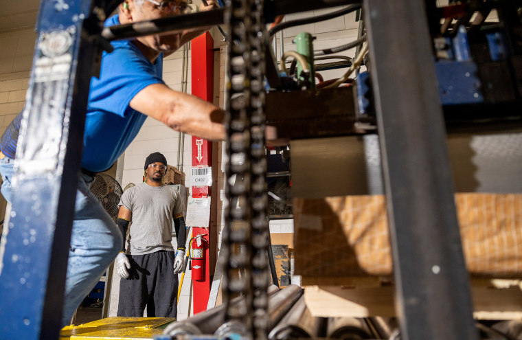 Jose Zuniga, left, and Zach Powell run a printing press on Friday, July 18, 2025 in Belcamp, MD at Independent Can Company.