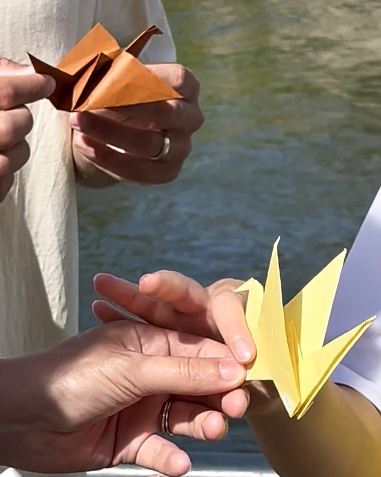 At the end of his tours, Sasaki, right, gives each person an origami crane symbolizing peace in Hiroshima.