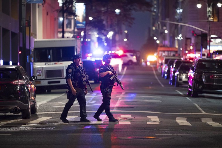 Police officers gather in a street as they respond to a shooting incident in the Midtown Manhattan neighborhood of New York on July 28, 2025 in New York City. 
