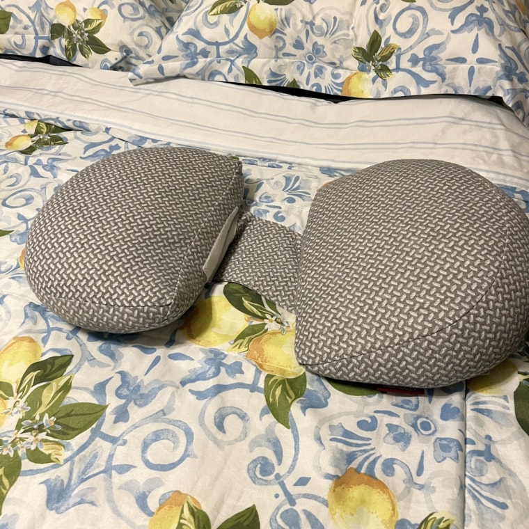 Momcozy wedge pillow on top of bedroom comforter