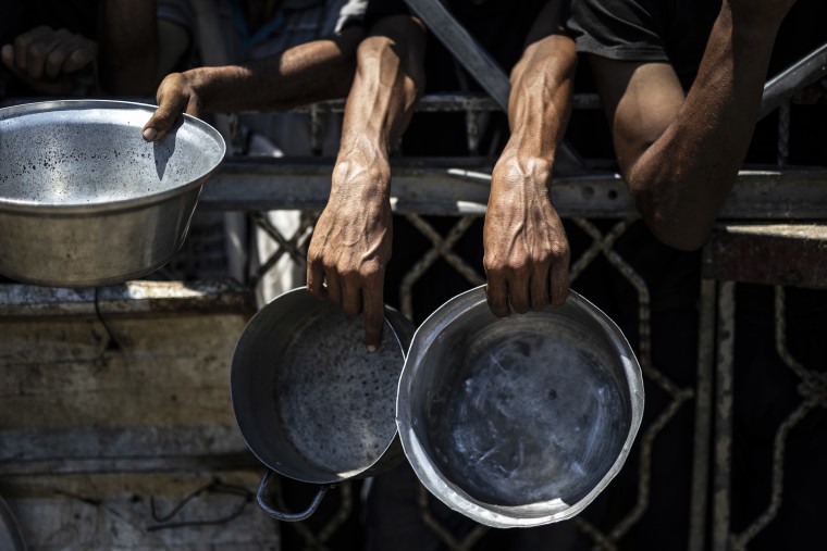 Palestinians struggle with hunger in Gaza wait for food despite the heat