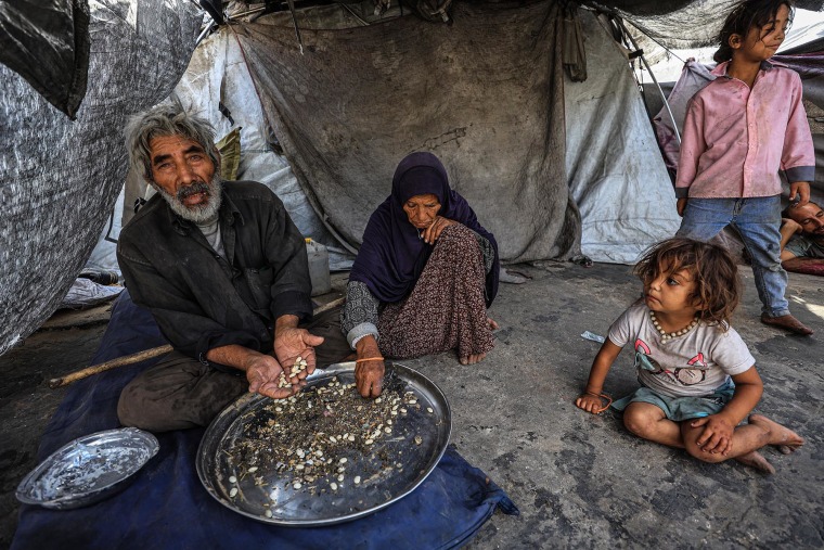 Abdulhadi Subh shows the food scraps picked out from waste material in Yarmouk camp in Gaza City on July 30, 2025.