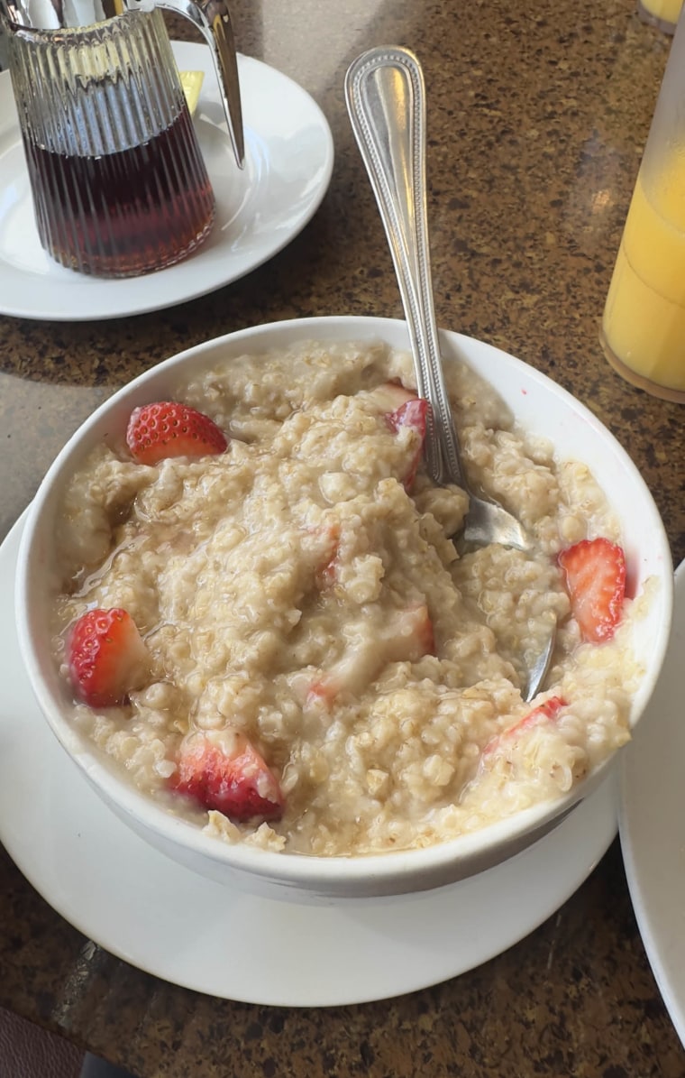 a bowl of oatmeal with berries and maple syrup.