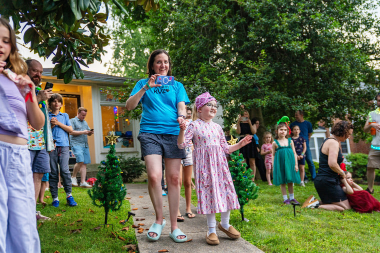 Kacey and her mother approach the parade in front of their home.