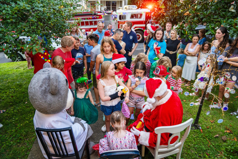 Neighbors gather in front of Kacey's home to see her and Santa.