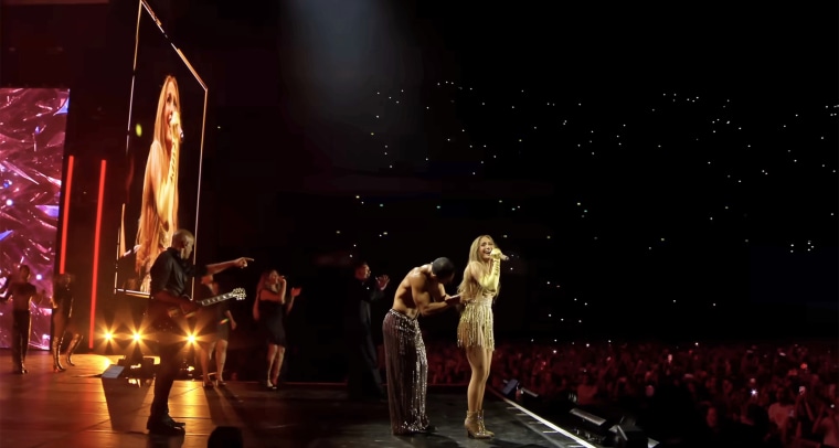 A backup dancer did his best to put Lopez's skirt back on.