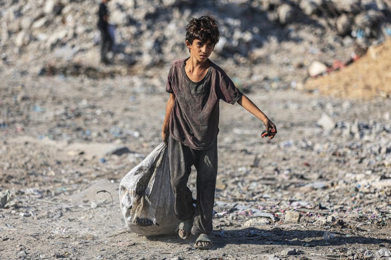 Palestinians in Gaza search through piles of rubbish to find food and basic supplies
