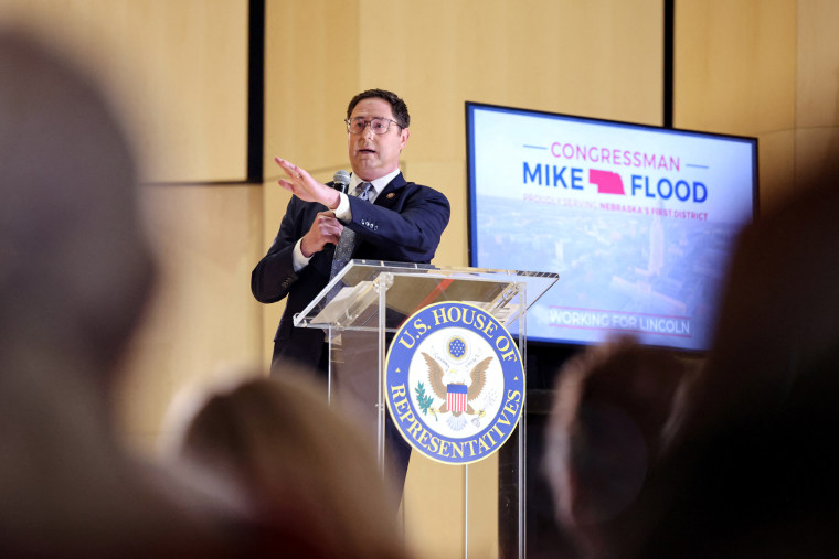 Mike Flood speaks at a podium, a screen behind him says "Congressman Mike Flood"
