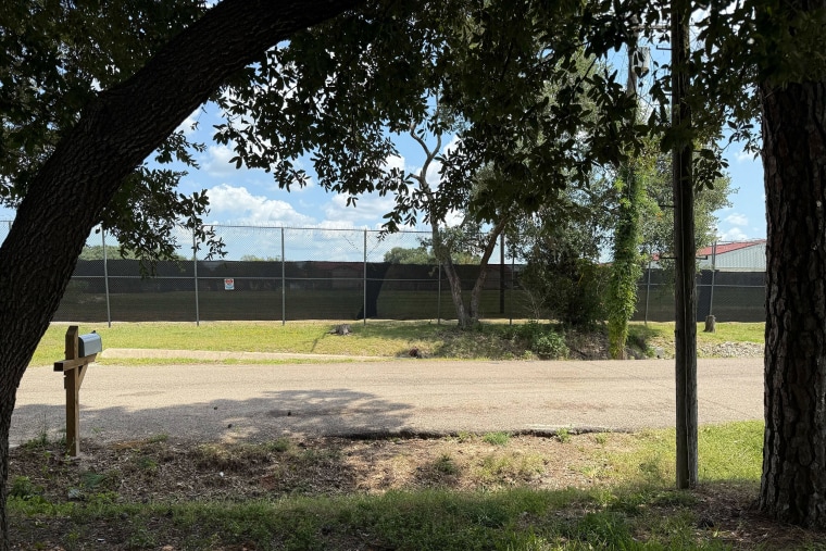 Dark privacy windscreens pinned up on fences circling the prison block public views of the running path on Friday.