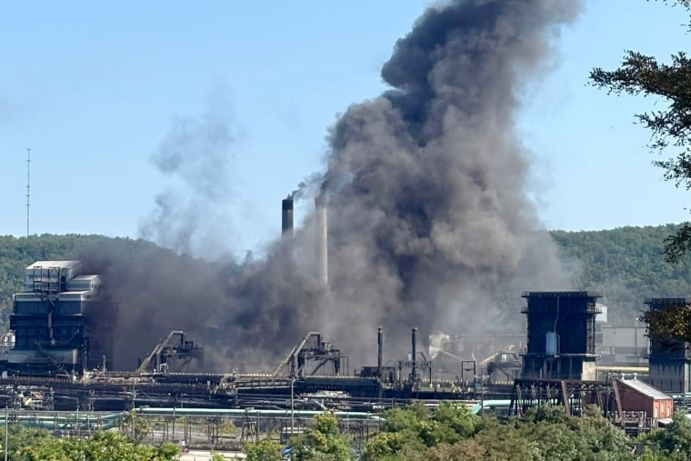 Smoke billows into the sky above a steel factory.