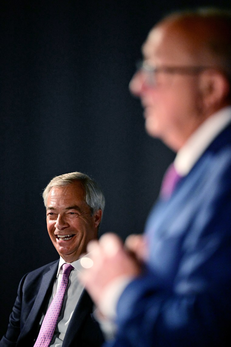 Reform UK Leader Nigel Farage looks on as Reform UK's Crime and Police adviser Colin Sutton speaks