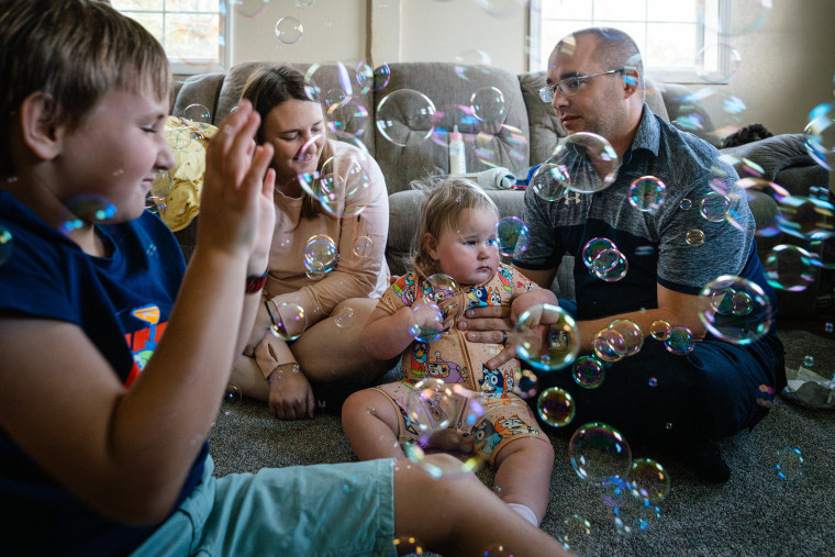 Carrie and Patrick play with bubbles with their 9-year-old son, Liam Barth, and Emmalyn.