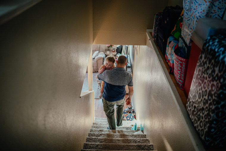 Patrick Lazoen carries Emmy downstairs.