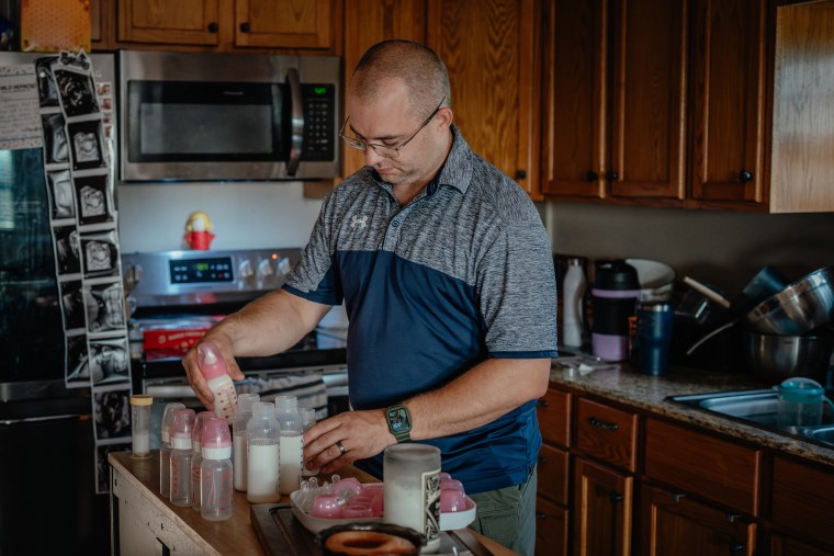 Patrick Lazoen prepares bottles of formula for Emmalyn.