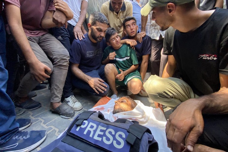 Relatives of Reuters contractor Hussam al-Masri, who was killed during an Israeli strike on Nasser hospital in Khan Younis in the southern Gaza Strip, mourn over his body ahead of his funeral on Aug. 25, 2025.