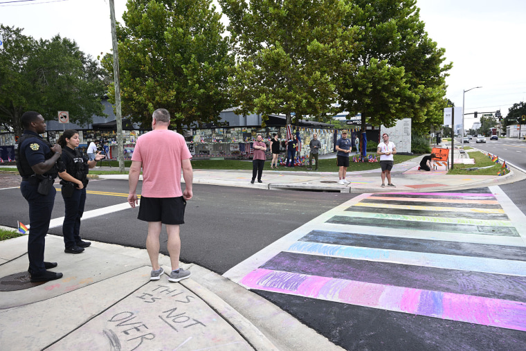 Orlando Police officers warn people not to apply chalk to the crosswalk outside of the Pulse Interim Memorial,