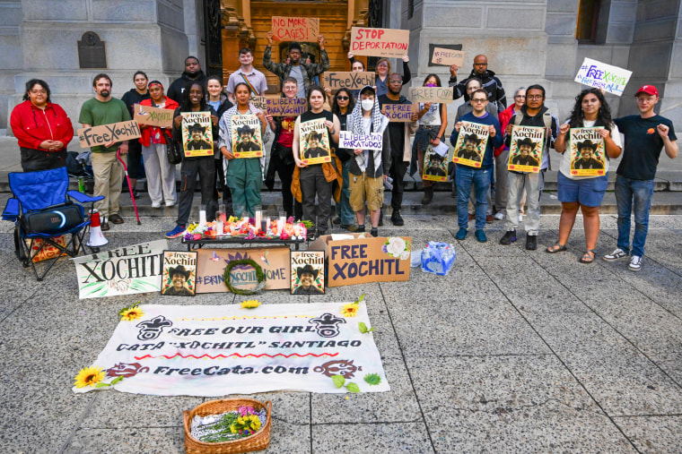 People hold protest signs outside