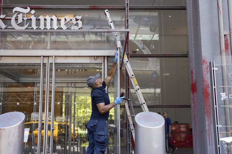 The workers eliminate the red paint dotted on the facade of the New York Times building on July 30, 2025.