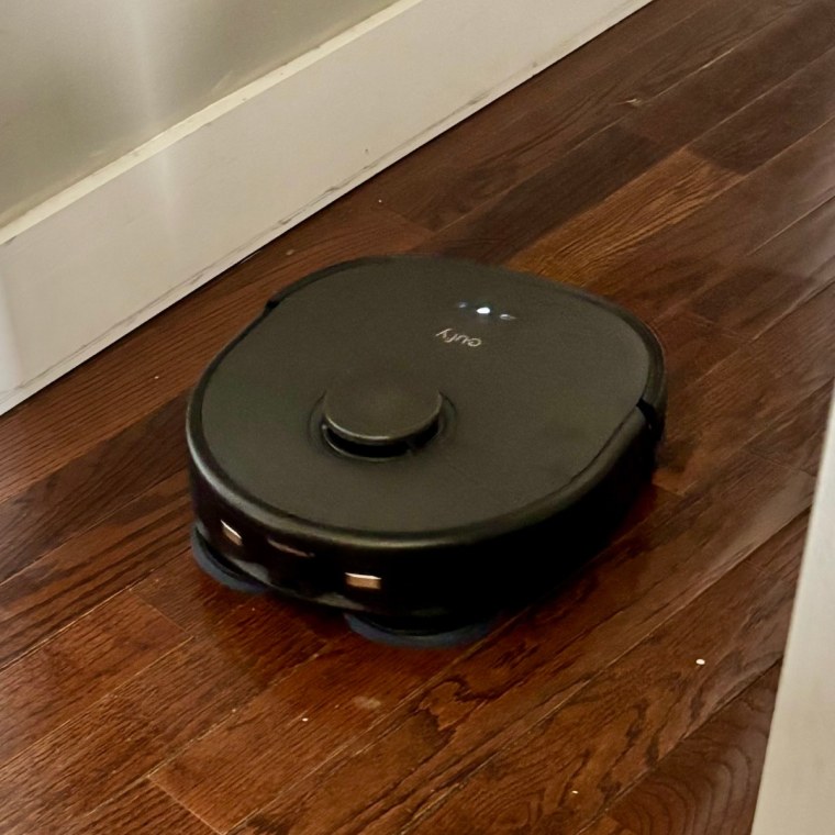 A photo of the Eufy Omni X10 Pro mopping a dark hardwood floor.