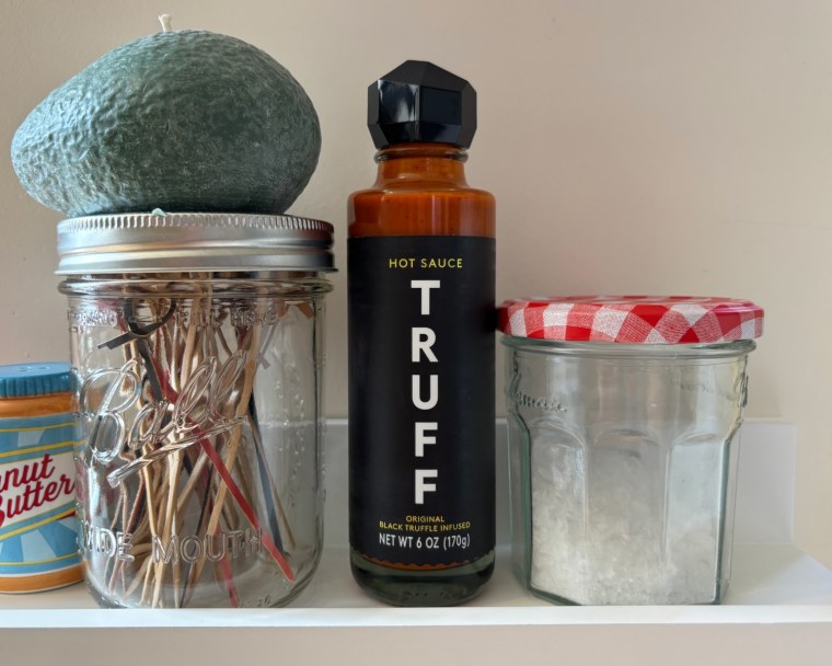 A bottle of Truff Original Black Truffle Hot Sauce on a shelf.