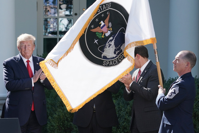 President Donald Trump applauds as the flag for the new the U.S. Space Command is revealed