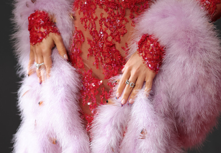 Details of Sabrina Carpenter's boa and custom rings.