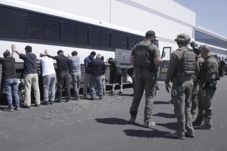 manufacturing plant employees waiting to have their legs shackled at the Hyundai Motor Group’s electric vehicle plant