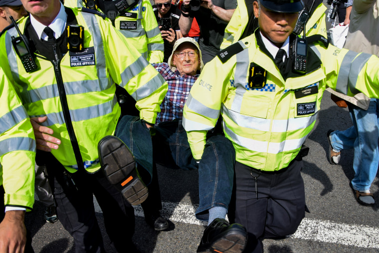 Police officers arrest a protester in Parliament Square who