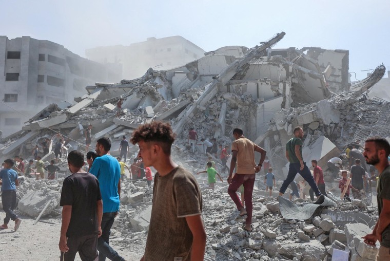 Palestinians search the rubble of al-Ghafari tower after its destruction by Israeli airstrikes in Gaza City on Sept. 15, 2025.