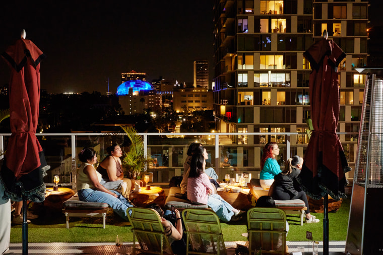 People at a rooftop watch party for "The Summer I Turned Pretty."