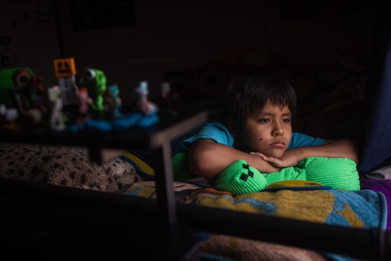 Isaiah rests on a green pillow on his bed