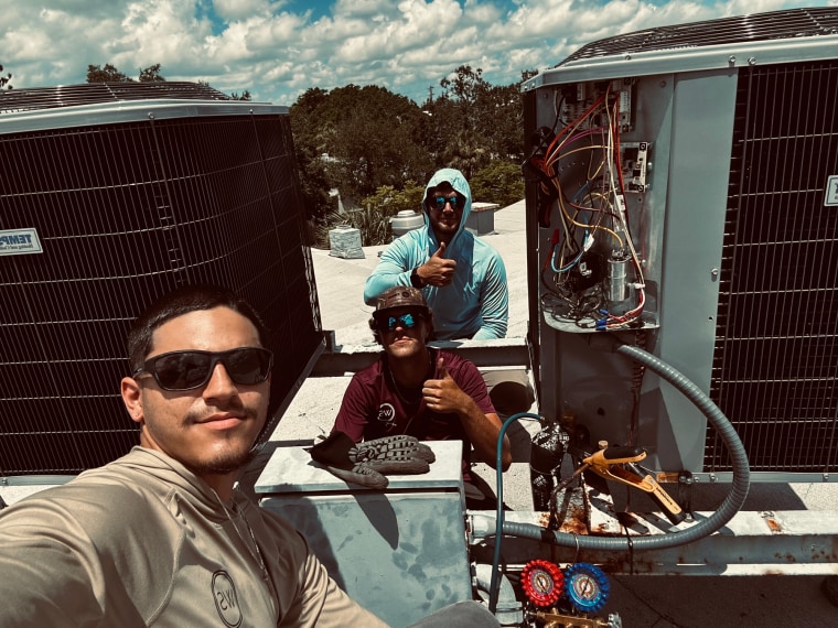 Andrew Salgado, left, and two others work on A/C units outside