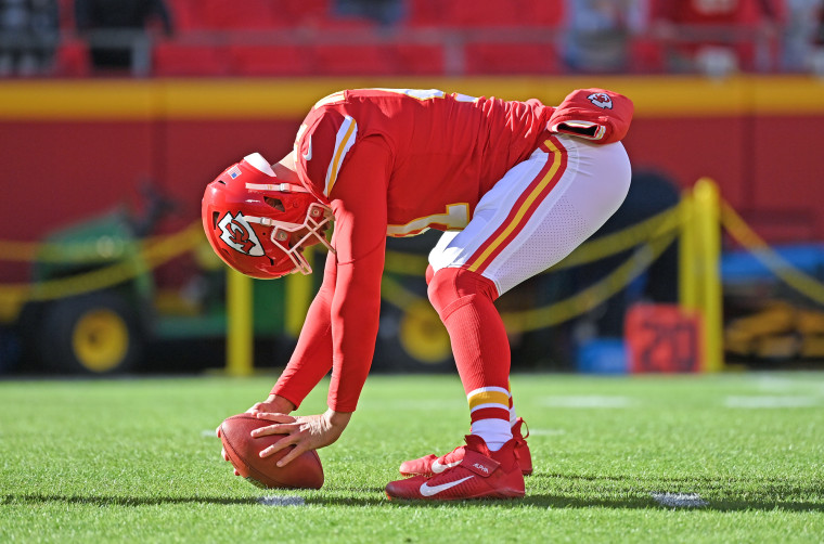 James Winchester curls down to the ground with a football on the field