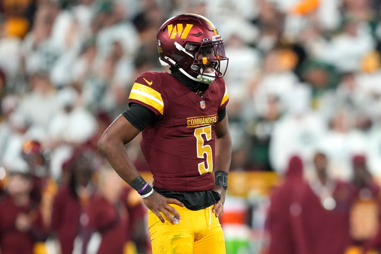 Jayden Daniels #5 of the Washington Commanders reacts after being hit.
