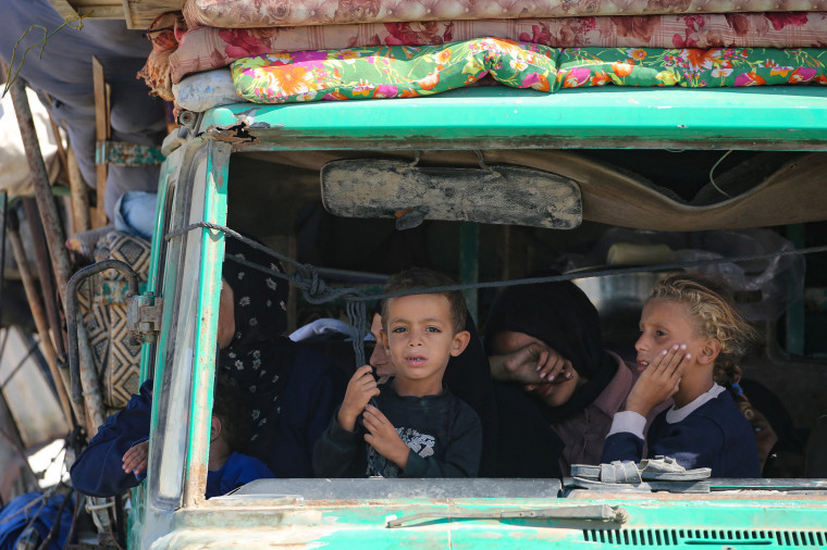 Palestinians from Gaza City ride in a truck as they move southwards with their belongings