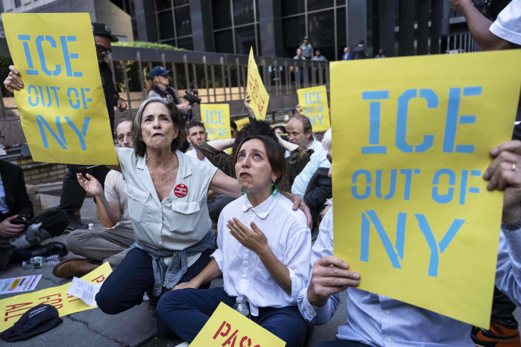 Demonstrators, holding yellow and blue signs that read "ICE Out of NY" chant during a protest against Immigration and Customs Enforcement