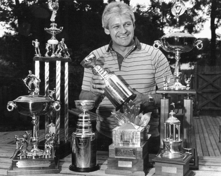 Bernie Parent surrounded by hockey trophies.