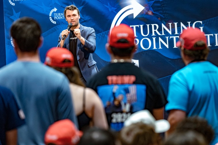 Charlie Kirk speaks in front of an audience on stage