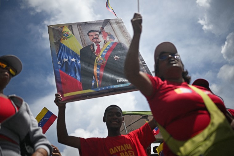 A man holds a portrait of Venezuelan President Nicolas Maduro during a march in support of him in Caracas on Sept. 23, 2025. 