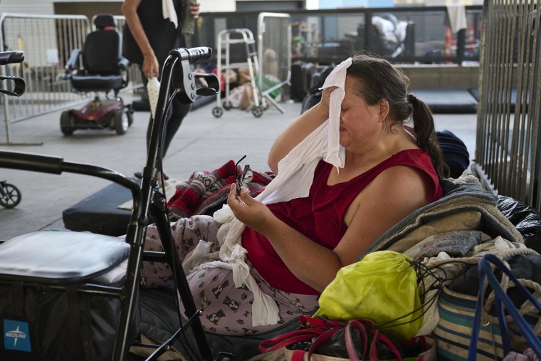 Kathy Jones, 56, wipes her face in the heat at the outdoor Courtyard Homeless Resource Center in Las Vegas on July 11, 2024.