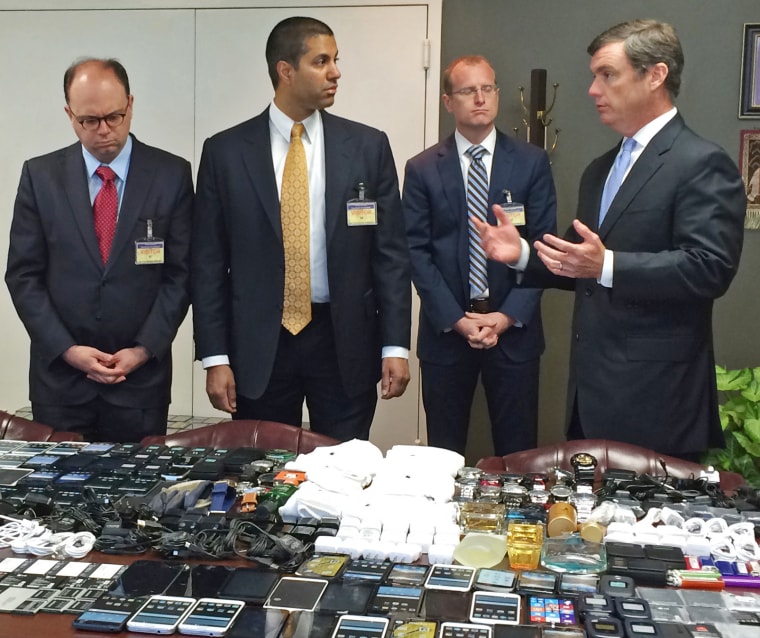 South Carolina Department of Corrections Director Bryan Stirling, right, shows FCC officials in 2016 hundreds of cellphones that were seized in a single raid from the Lee Correctional Institution. From left, Matthew Berry, FCC Commissioner Ajit Pai and  Brendan Carr. 