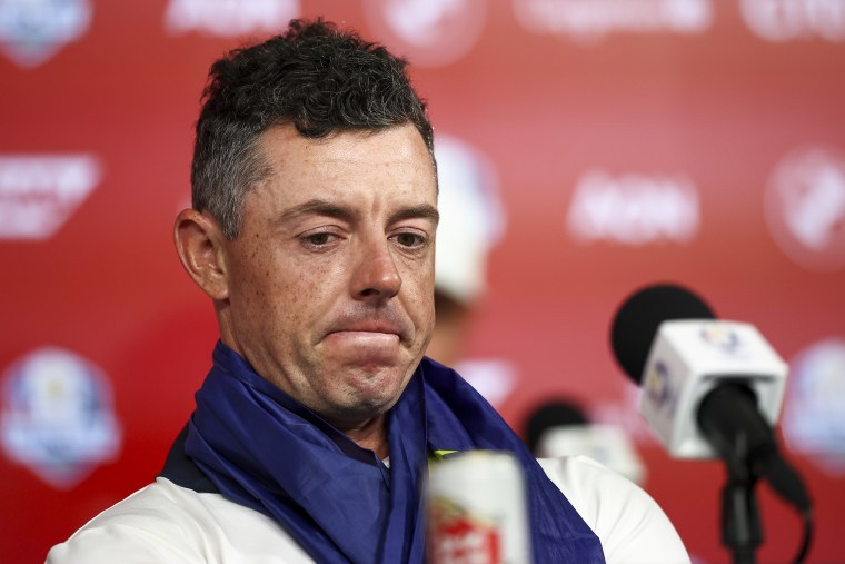 Rory McIlroy sits in front of a microphone.