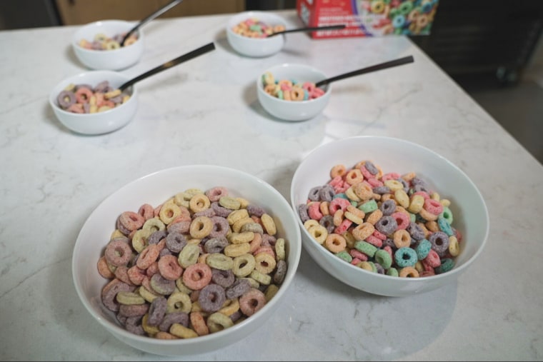 Two rows of bowls of cereal on a counter