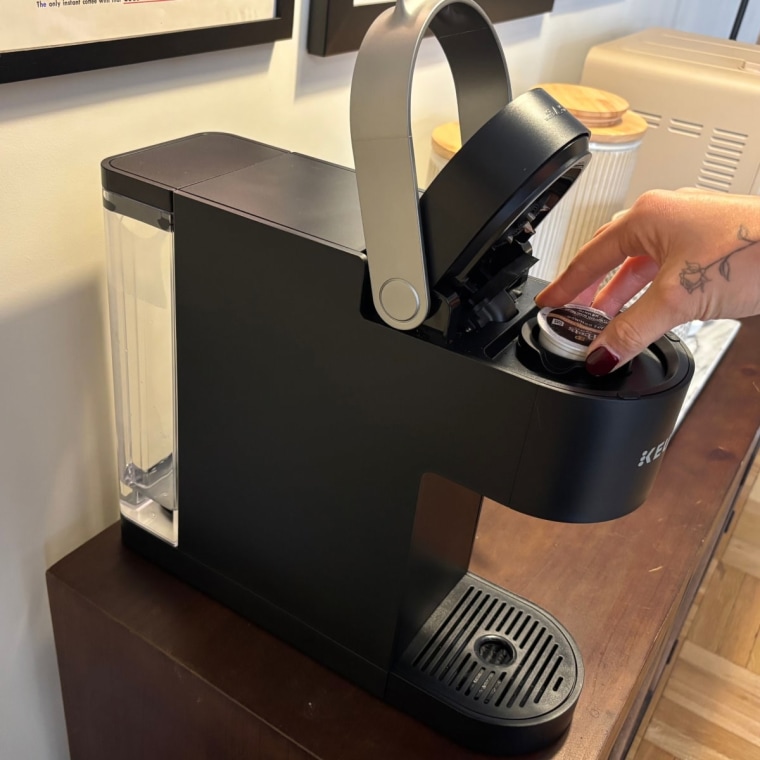 A black Keurig K-Slim Single-Serve Coffee Maker on a wood countertop.