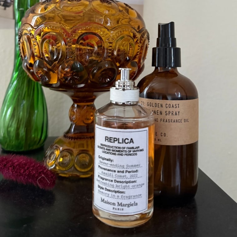 Image of perfume bottle on a stand with decor surrounding it.