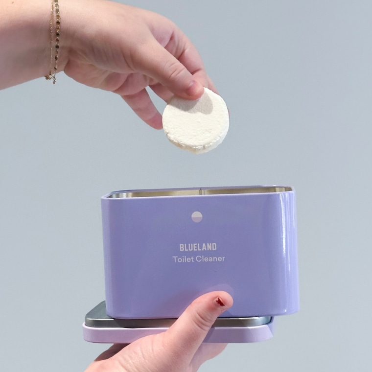 Shigo holding one of Blueland's Toilet Bowl Cleaner tablets